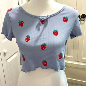 A cute and trendy new never worn is a light baby blue croptop with strawberries